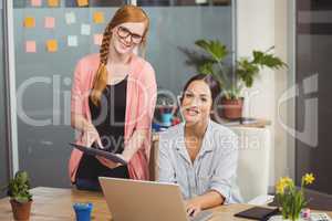 Portrait of businesswomen using technologies in office