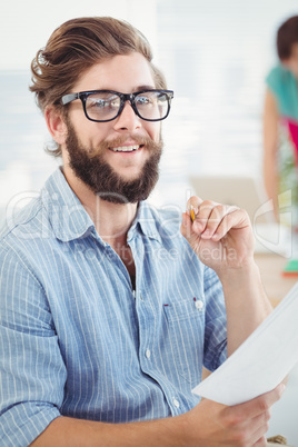 Portrait of smiling man holding pen and paper