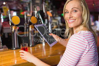 Portrait of woman with drink holding digital tablet