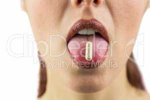Close-up of woman with pill in mouth