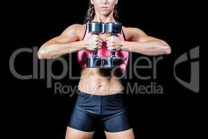 Midsection of slim woman exercising with dumbbells