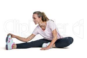 Happy woman touching toes while exercising