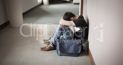 Depressed male student with head on knees
