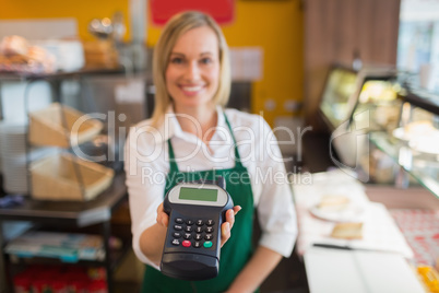 Female shop owner holding credit card reader