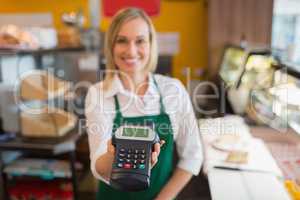 Female shop owner holding credit card reader