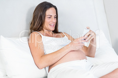 Happy pregnant woman using smartphone