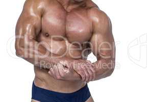 Midsection of shirtless man flexing  muscles