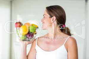 Happy woman looking at fruit bowl