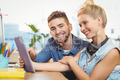 Employee with female colleague using digital tablet