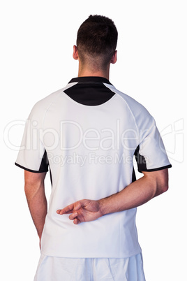 Rear view of rugby player with fingers crossed