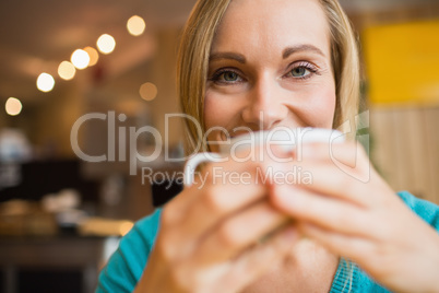 Portrait of young woman drinking coffee in cafe