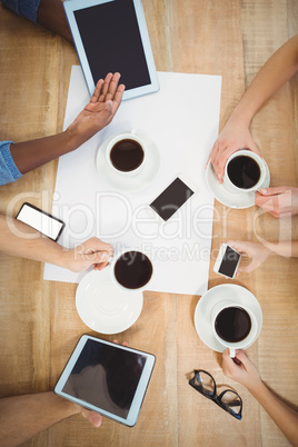 Overhead view of people using technology with person showing dig