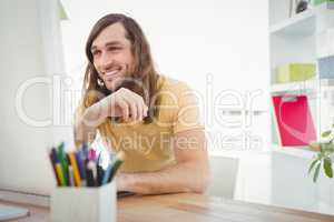 Hipster smiling while working at computer desk