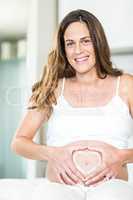 Portrait of happy woman with heart on belly