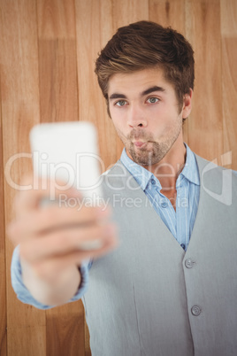Businessman making face while taking selfie