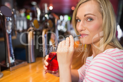 Portrait of young woman sipping drink