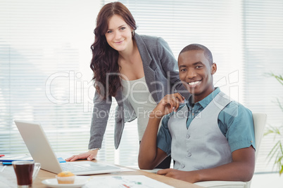 Portrait of smiling business professionals working on laptop