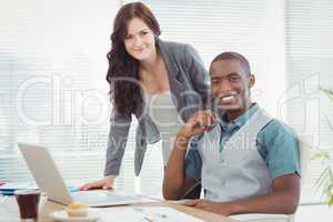 Portrait of smiling business professionals working on laptop