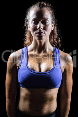 Woman relaxing against black background