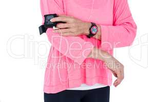 Mid section of woman using mp3 player in armband
