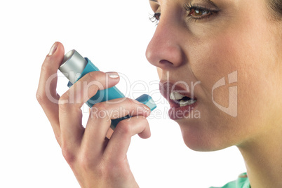 Close-up of woman looking away while using asthma inhaler
