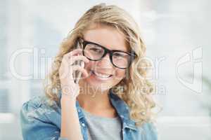Portrait of smiling woman wearing eyeglasses while talking on sm