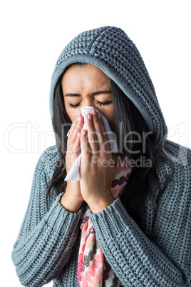 Woman sneezing into her tissue