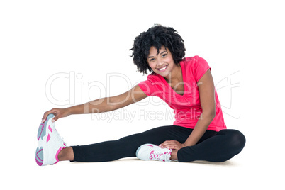 Portrait of young woman touching toes while exercising