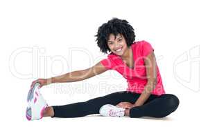 Portrait of young woman touching toes while exercising