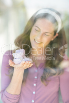 Happy woman with baby shoes