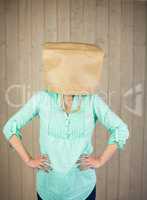 Woman with hands on hip and covering head with brown paper bag