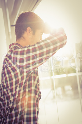 Low angle view of hipster looking through window