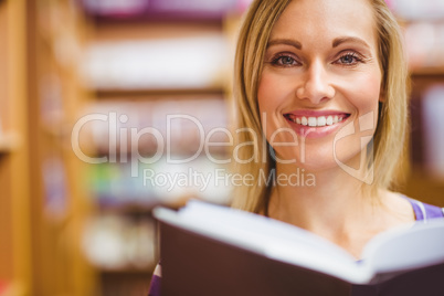 Portrait of happy young woman with book