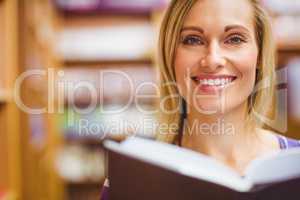 Portrait of happy young woman with book