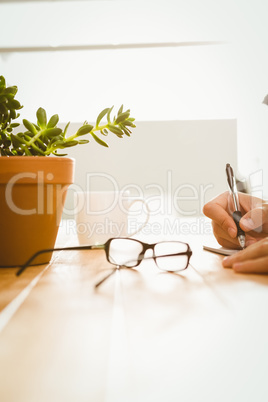 Man writing on book at desk in office