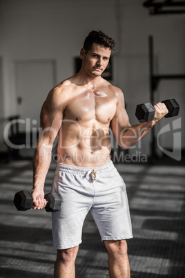 Muscular serious man doing weightlifting