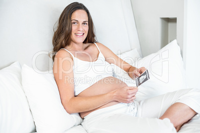 Portrait of happy woman with sonogram