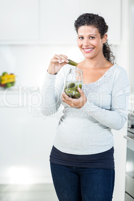 Portrait of beautful pregnant woman eating a pickle