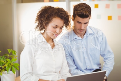 Business woman using digital tablet while male colleague