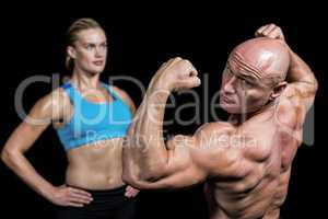 Muscular man flexing muscles in front of instructor