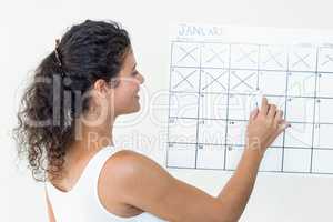 Pregnant woman marking off dates on calendar