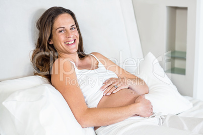 Portrait of cheerful woman relaxing on bed