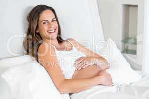 Portrait of cheerful woman relaxing on bed