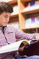 Concentrated man reading book in library