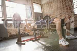 Man holding barbell lying on bench