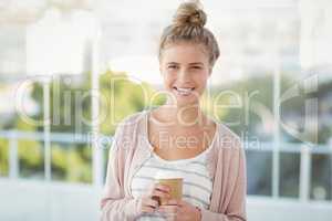 Portrait of smiling woman holding coffee cup