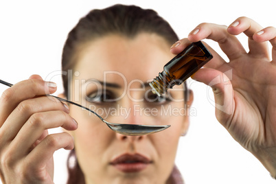 Close-up of woman taking medicine with spoon