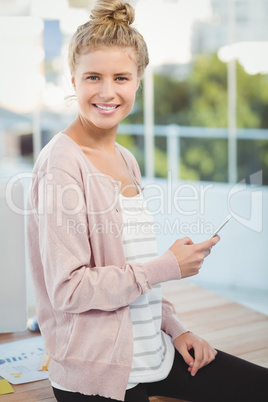 Portrait of smiling woman holding smartphone