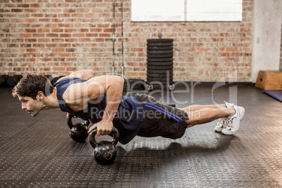 Man doing push ups with kettlebell