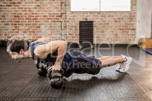 Man doing push ups with kettlebell